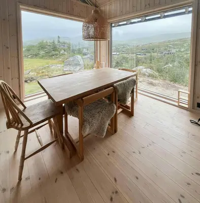 a wooden table and chairs in a room with a window at Architect-Designed Cabin With Views Of Sigdal in Eggedal