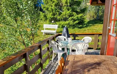 a table and chairs on the deck of a house at 3 Bedroom Beautiful Home In Tynset in Tynset