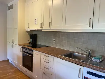 a kitchen with white cabinets and a sink at Stor Leilighet Med 4 Soverom Og 2 Bad in Beitostøl