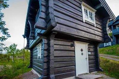 a tiny house with a white door and windows at Trysilfjellet Nord 901 stabur in Trysil