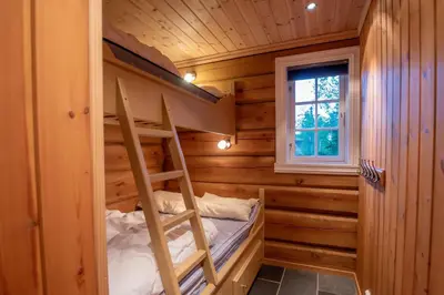 a bunk bed in a log cabin with a ladder at Trysilfjellet Nord 901 stabur in Trysil