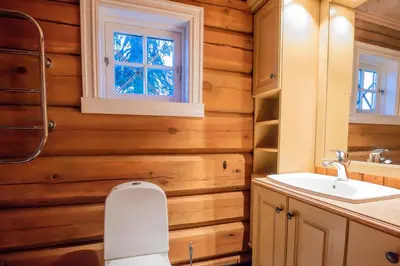 a bathroom with wooden walls and a sink and a window at Trysilfjellet Nord 901 stabur in Trysil