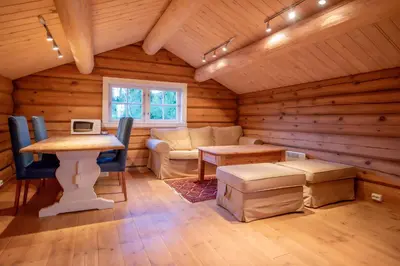 a living room with a table and a couch in a log cabin at Trysilfjellet Nord 901 stabur in Trysil