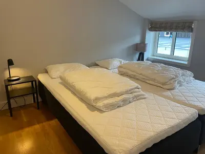 two twin beds in a room with a window at Stor Og Moderne Leilighet I Sentrum in Beitostøl