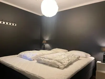 a bed in a bedroom with a black wall at Stor Og Moderne Leilighet I Sentrum in Beitostøl