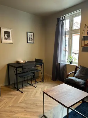 a living room with a table and a couch at Cozy place in the city center, Bergen! in Lii
