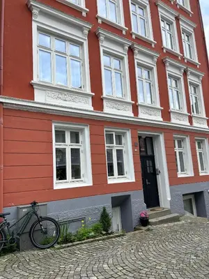a bike parked in front of a red building at Cozy place in the city center, Bergen! in Lii