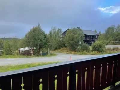 a bridge over a road with a house in the distance at Leilighet for 4 i sentrum in Beitostøl