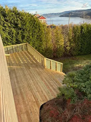 a wooden deck with a view of the water at Cozy house with a sea view in Knarrvika