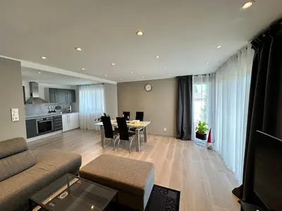 a living room with a couch and a table with chairs at Cozy house with a sea view in Knarrvika