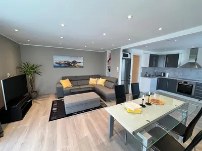 a living room with a couch and a table at Cozy house with a sea view in Knarrvika