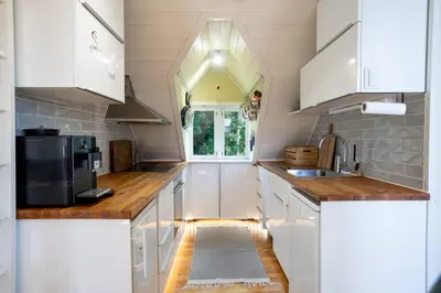 a kitchen with white cabinets and a window at Privat rom i koselig Bergenshus in Bergen