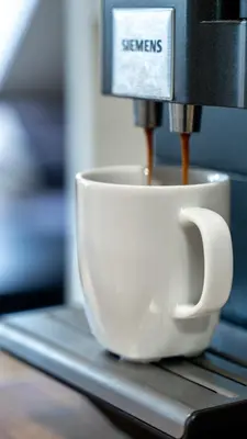a coffee maker is making a coffee cup on a counter at Privat rom i koselig Bergenshus in Bergen