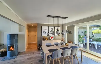 a dining room with a table and a fireplace at Beautiful Home In Bjørøyhamn With House Sea View in Nord Bjørøy