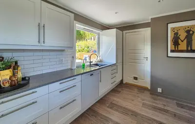 a kitchen with white cabinets and a window and a sink at Beautiful Home In Bjørøyhamn With House Sea View in Nord Bjørøy