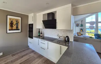 a kitchen with white cabinets and a counter top at Beautiful Home In Bjørøyhamn With House Sea View in Nord Bjørøy