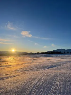 a beach with the sun setting on the horizon at New cabin in beautiful surroundings in Oppdal