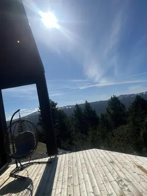 a chair on a deck with a view of the mountains at New cabin in beautiful surroundings in Oppdal