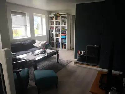 a living room with a couch and a table at Koselig hus med flott utsikt in Vossevangen