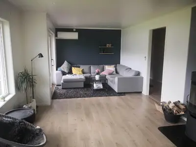 a living room with a couch and a table at Koselig hus med flott utsikt in Vossevangen