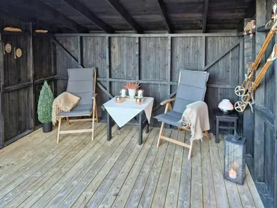 a patio with two chairs and a table on a deck at Mountain Gem With Ski In And Out At Golsfjellet in Gol