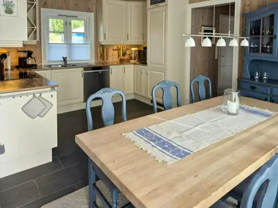 a kitchen with a wooden table and blue chairs at Mountain Gem With Ski In And Out At Golsfjellet in Gol