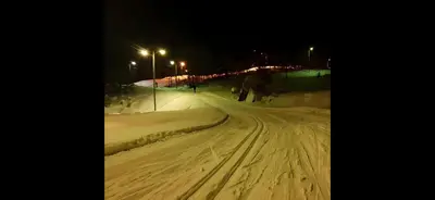a snow covered street at night with street lights at Storevatn Fritid in Masfjorden