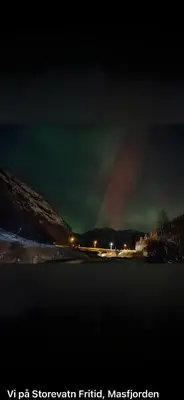 a rainbow in the sky over a lake at night at Storevatn Fritid in Masfjorden