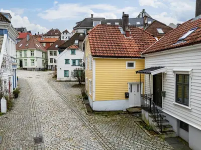 a street in a city with white and yellow houses at Charming apt in the centre of Bergen in Bergen