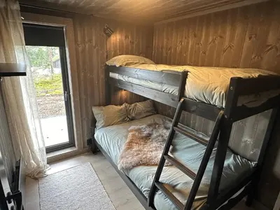 a bunk bed in a room with a ladder at Luxury holiday home, skiing, sauna, remote office in Nesbyen