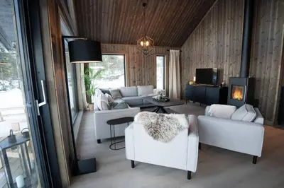 a living room with white furniture and a fireplace at Luxury holiday home, skiing, sauna, remote office in Nesbyen