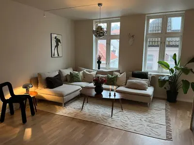 a living room with a couch and a table at Stay centrally in a charming and peaceful neighborhood in Bergen