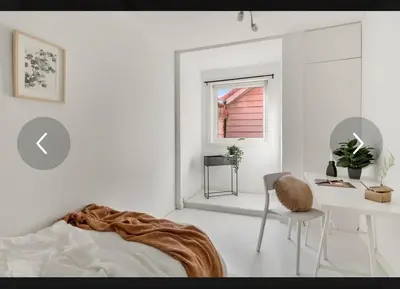 a bedroom with a bed and a desk and a window at Stay centrally in a charming and peaceful neighborhood in Bergen