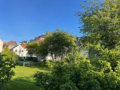 a view of a yard with trees and houses at Stay centrally in a charming and peaceful neighborhood in Bergen