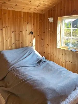 a bed in a wooden room with a window at Family Cabin At Birkebeiner Slopes In Sjusjøen in Sjusjøen