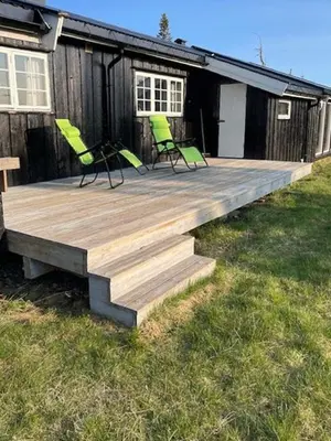 two chairs sitting on a wooden deck in front of a house at Family Cabin At Birkebeiner Slopes In Sjusjøen in Sjusjøen