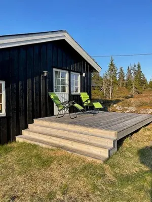 a house with two chairs on a wooden deck at Family Cabin At Birkebeiner Slopes In Sjusjøen in Sjusjøen