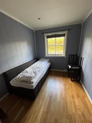 a bedroom with a bed in a room with a window at 75 sqm with terrace and garden in Elverum