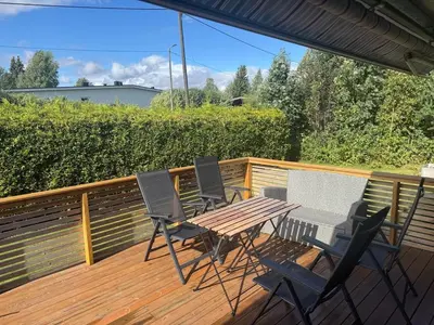 four chairs and a table on a deck at 75 sqm with terrace and garden in Elverum