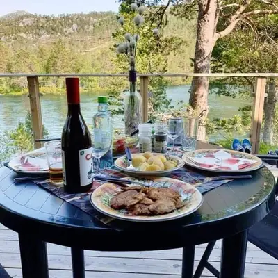 a table with plates of food and a bottle of wine at Hytte ved Gaularfjellet in Viksdalen