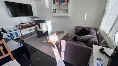 a living room with a couch and a tv at Litla Hyttå, Mosterhamn Bømlo in Mosterhamn