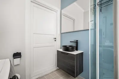 a bathroom with a sink and a glass shower at Bergen Beds Apartments - A Front Row Experience in Bergen