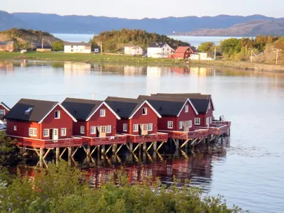 a row of houses on a dock on a body of water at Seaside Retreat with Boats & Fishing in Brekstad