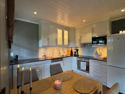 a kitchen with white cabinets and a table with candles at Cozy apartment in Vestlia, Geilo in Geilo