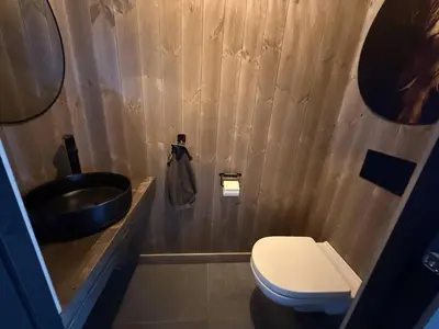 a bathroom with a toilet and a sink at Tiur, stylish new cabin with hot tub in Nesbyen