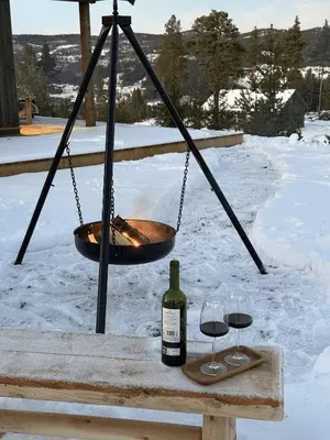 a bottle of wine and two glasses on a table at Tiur, stylish new cabin with hot tub in Nesbyen