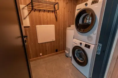 a washing machine and a washer in a bathroom at Tiur, stylish new cabin with hot tub in Nesbyen