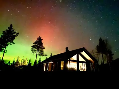 a house under a starry sky with the milky way at Tiur, stylish new cabin with hot tub in Nesbyen