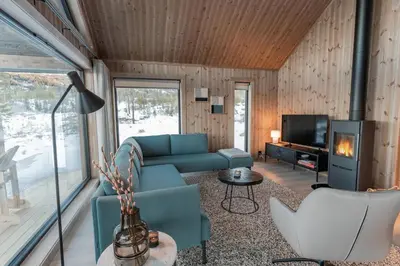 a living room with a couch and a tv at Tiur, stylish new cabin with hot tub in Nesbyen