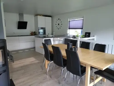 a kitchen and dining room with a wooden table and chairs at Koselig hus med flott utsikt in Vossevangen